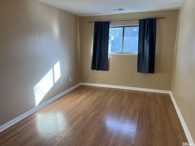 spare room with hardwood / wood-style flooring