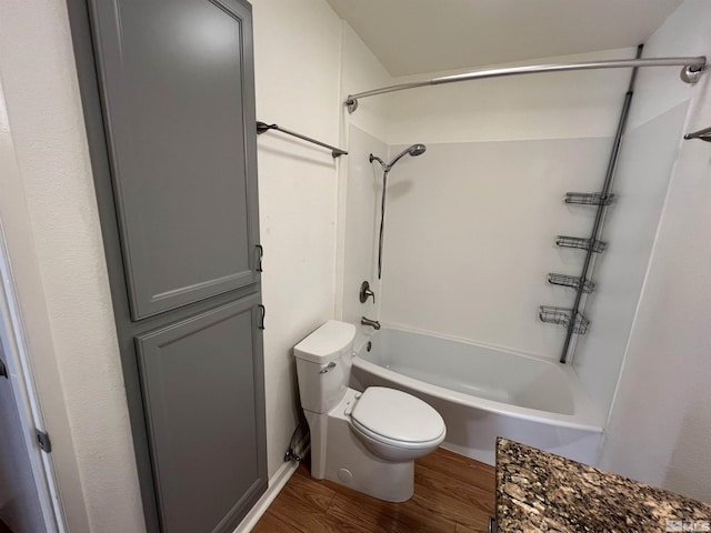 bathroom featuring bathtub / shower combination, hardwood / wood-style floors, and toilet