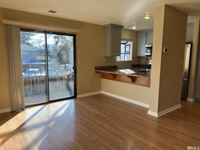 kitchen featuring stainless steel appliances, gray cabinets, sink, and dark hardwood / wood-style floors