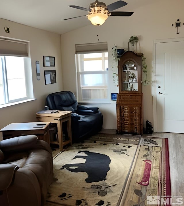 living area featuring wood-type flooring, lofted ceiling, and ceiling fan