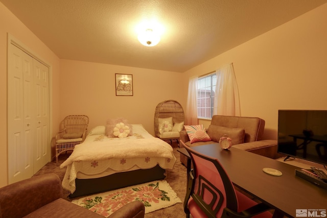 bedroom featuring a closet, a textured ceiling, and carpet flooring