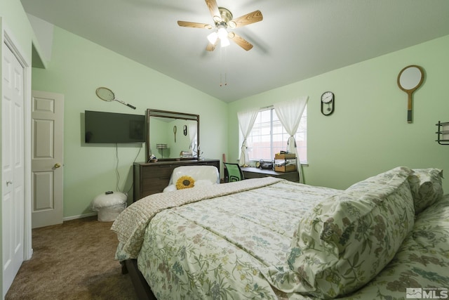 bedroom with ceiling fan, lofted ceiling, a closet, and dark colored carpet