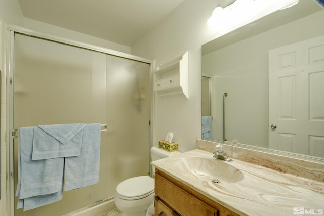 bathroom with vanity, toilet, and a shower with shower door