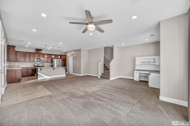 unfurnished living room featuring light colored carpet and ceiling fan