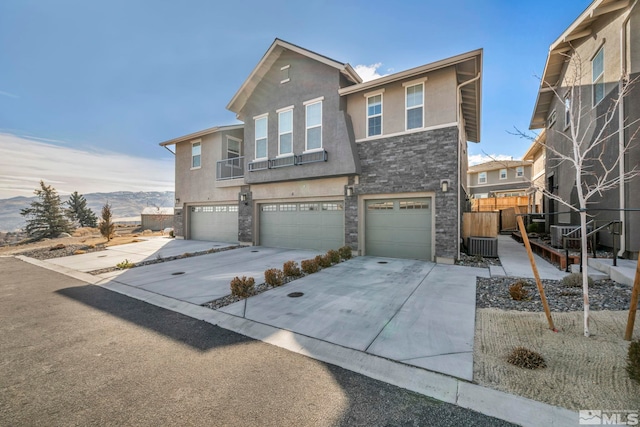 view of front of property featuring central AC, a garage, and a mountain view