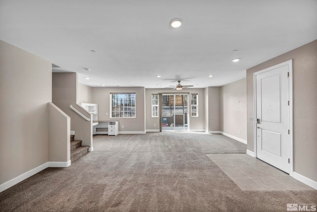 basement featuring light colored carpet and ceiling fan