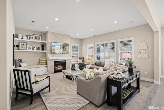 living room with a premium fireplace and light hardwood / wood-style flooring