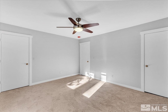 carpeted spare room featuring ceiling fan