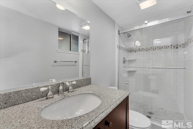 bathroom featuring vanity, toilet, and an enclosed shower