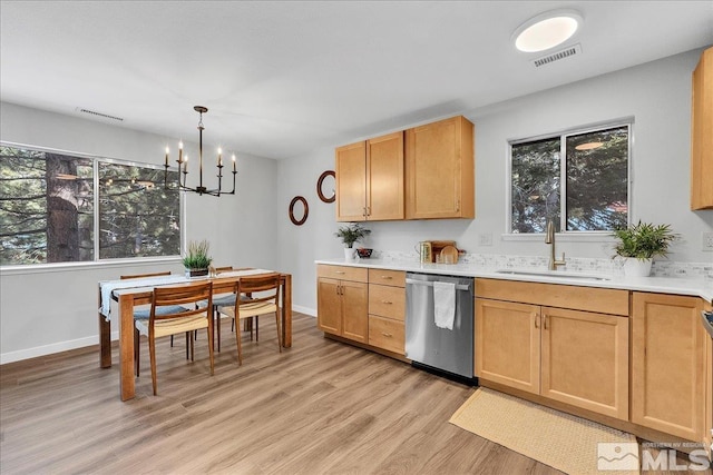 kitchen featuring sink, an inviting chandelier, decorative light fixtures, stainless steel dishwasher, and light wood-type flooring