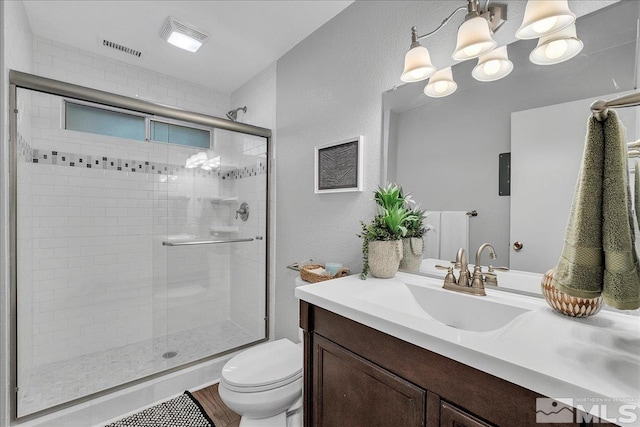 bathroom featuring hardwood / wood-style flooring, vanity, toilet, and a shower with door