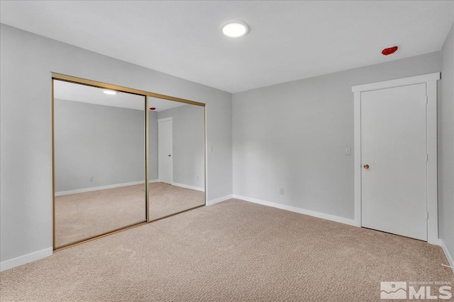 unfurnished bedroom featuring carpet floors and a closet