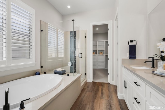 bathroom with vanity, wood-type flooring, and independent shower and bath