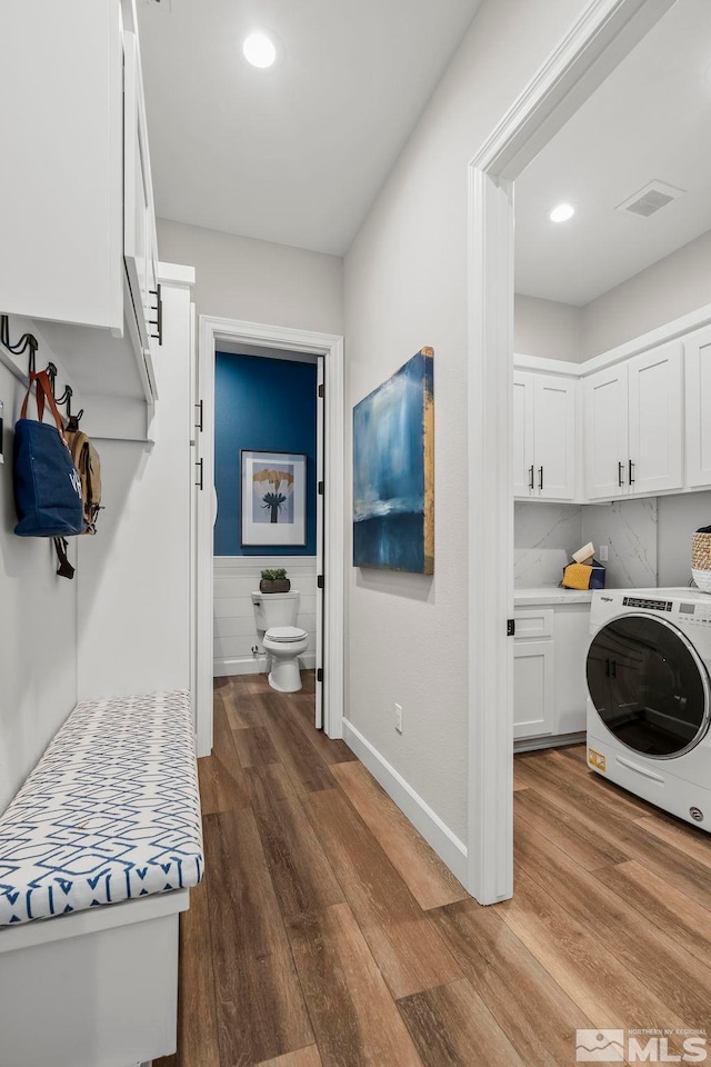 washroom featuring cabinets, washer / dryer, and dark wood-type flooring