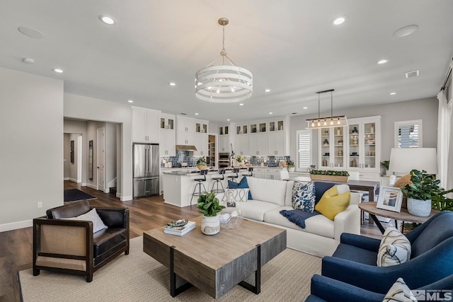 living room with light hardwood / wood-style flooring, a wealth of natural light, and a chandelier