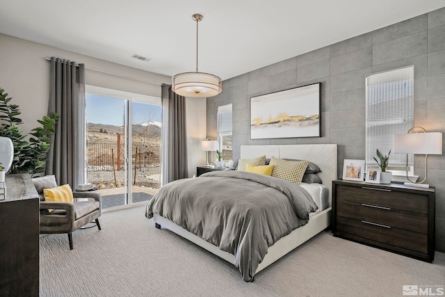 bedroom featuring light colored carpet, tile walls, and access to outside