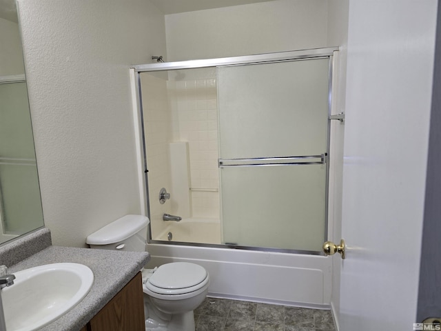 full bathroom with toilet, vanity, and bath / shower combo with glass door