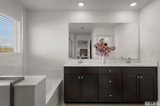 bathroom with vanity and a tub