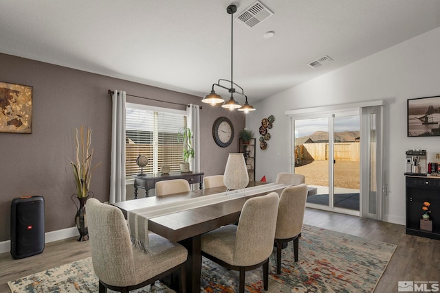 dining room with lofted ceiling and wood-type flooring