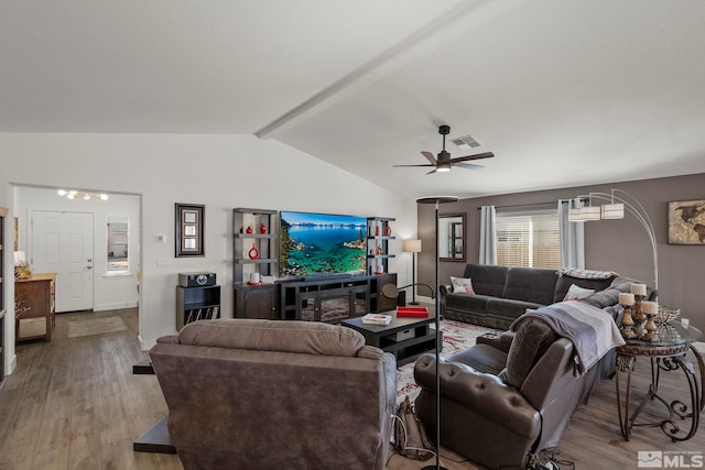 living room with vaulted ceiling with beams, ceiling fan, and light wood-type flooring