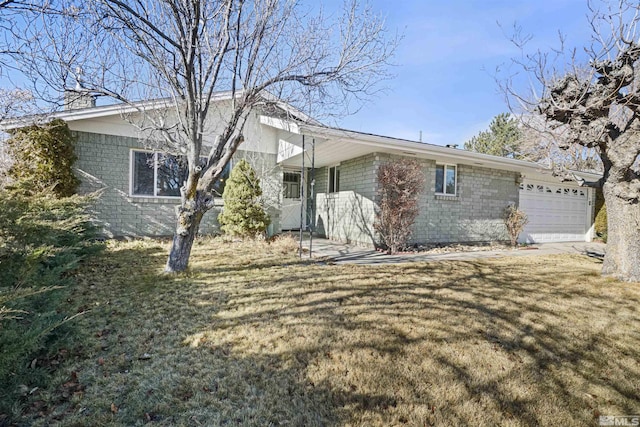 rear view of house featuring a yard and a garage