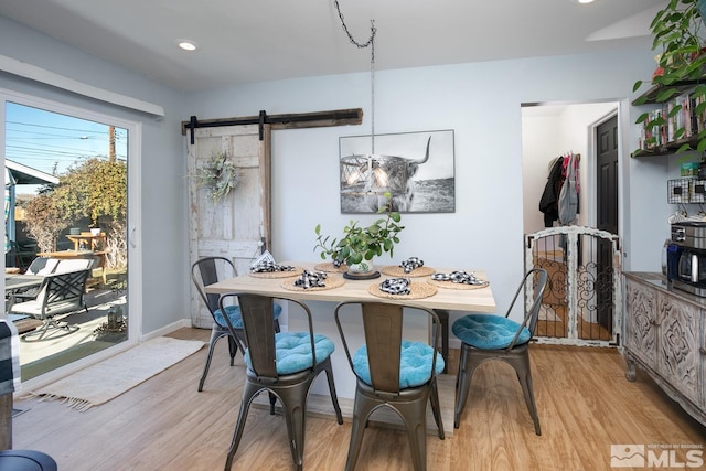 dining space featuring light hardwood / wood-style flooring and a barn door