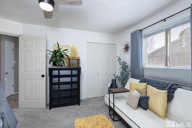 carpeted living room with ceiling fan