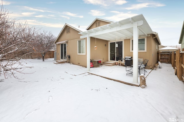 snow covered back of property featuring a pergola