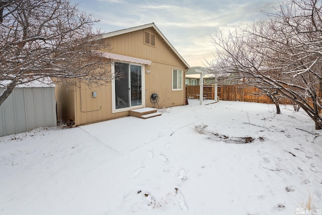 view of snow covered back of property