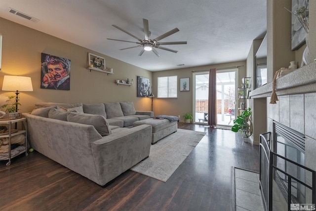 living room with dark hardwood / wood-style flooring, a fireplace, and ceiling fan