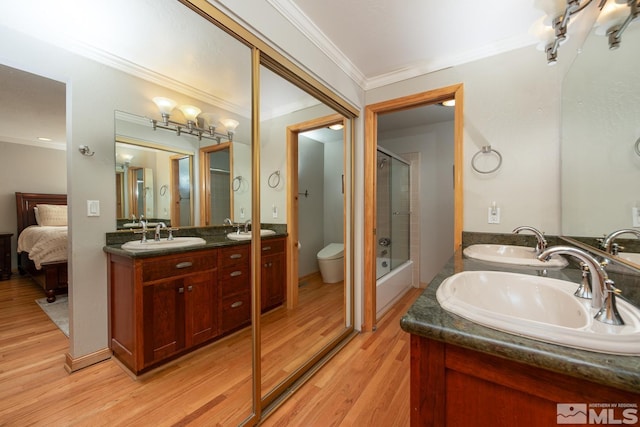 full bathroom with toilet, bathing tub / shower combination, ornamental molding, vanity, and hardwood / wood-style flooring