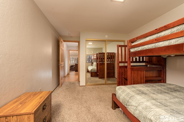 bedroom featuring light colored carpet and a closet