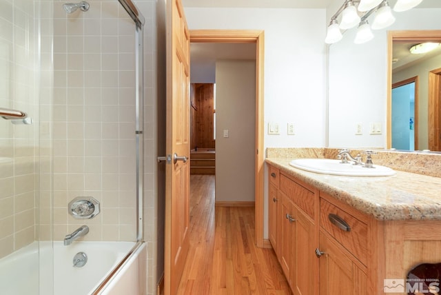 bathroom featuring vanity, hardwood / wood-style flooring, and tiled shower / bath