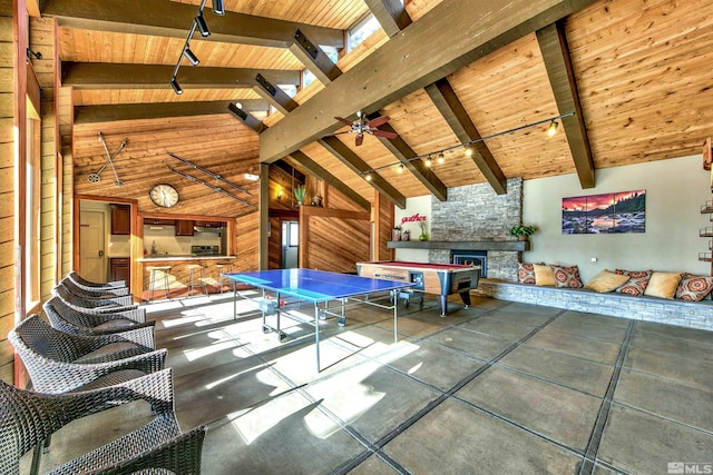 game room with high vaulted ceiling, wooden ceiling, track lighting, beamed ceiling, and a fireplace