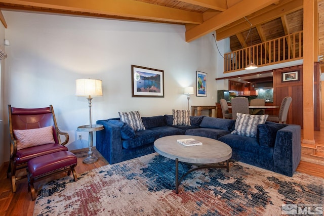 living room with vaulted ceiling with beams, hardwood / wood-style floors, and wooden ceiling