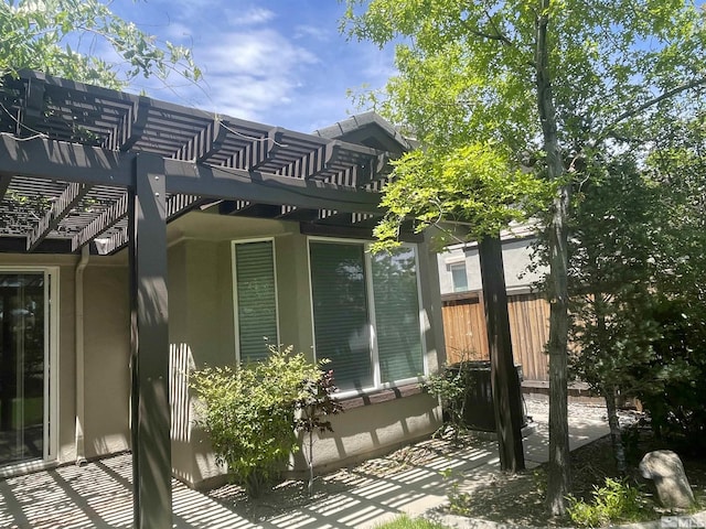 view of home's exterior with a patio area and a pergola