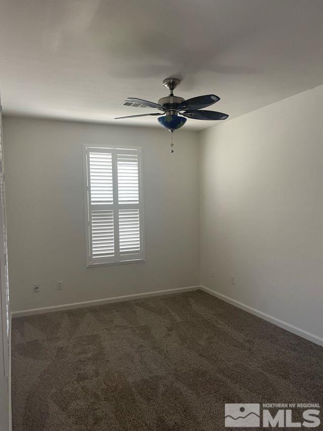 carpeted spare room featuring ceiling fan