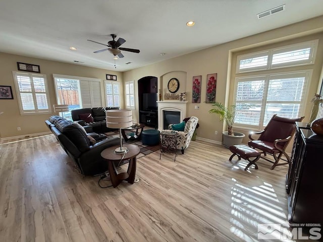 living room featuring ceiling fan and light hardwood / wood-style floors