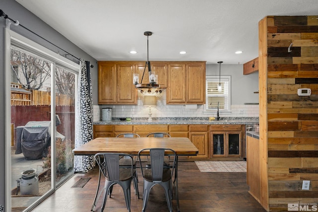 kitchen with hanging light fixtures, dark wood-type flooring, a wealth of natural light, and sink