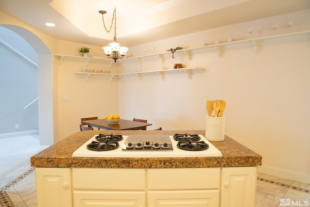 kitchen with light tile patterned floors, white gas stovetop, a notable chandelier, pendant lighting, and white cabinets