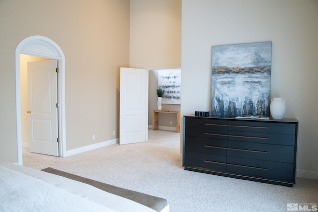 carpeted bedroom featuring a towering ceiling