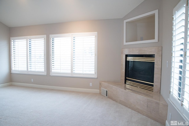 unfurnished living room with light carpet, a fireplace, and vaulted ceiling