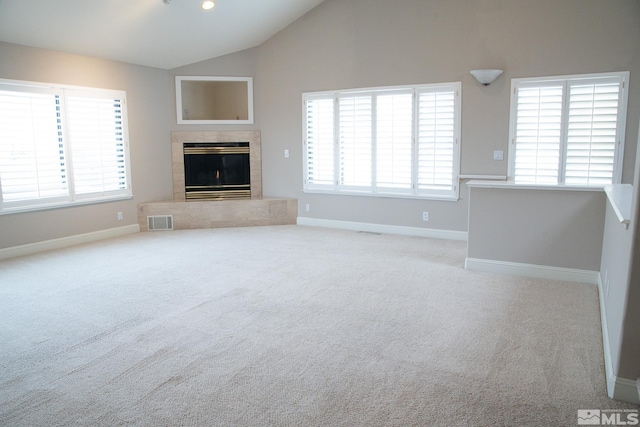 unfurnished living room with vaulted ceiling and light carpet