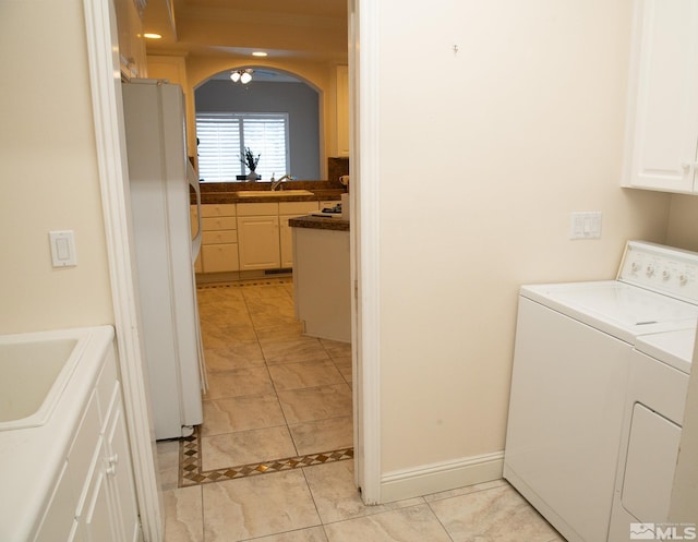 laundry room featuring cabinets, sink, washing machine and dryer, and light tile patterned floors