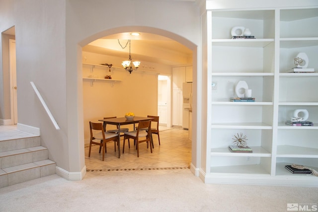 dining space with built in shelves and an inviting chandelier