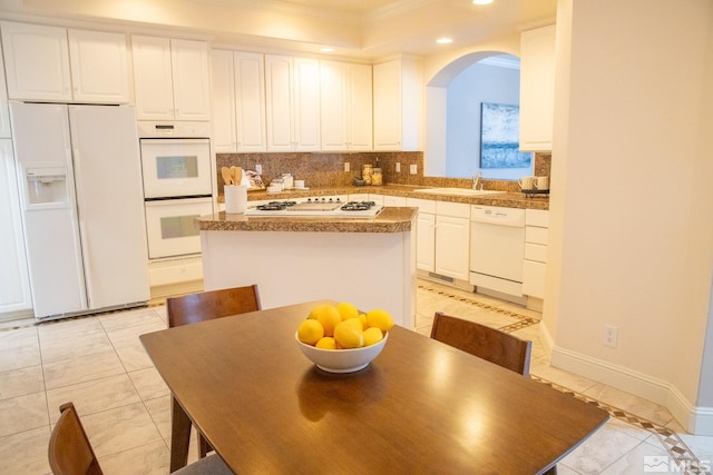 kitchen featuring white cabinetry, sink, light tile patterned floors, and white appliances