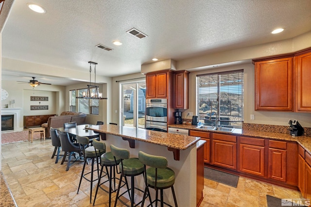 kitchen featuring pendant lighting, sink, a kitchen breakfast bar, stainless steel appliances, and a center island