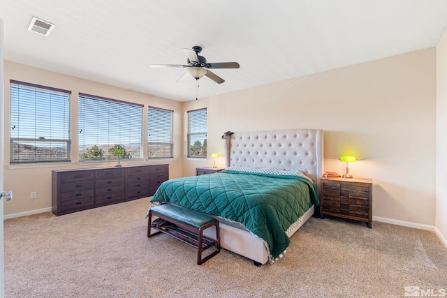 bedroom featuring multiple windows, light carpet, and ceiling fan