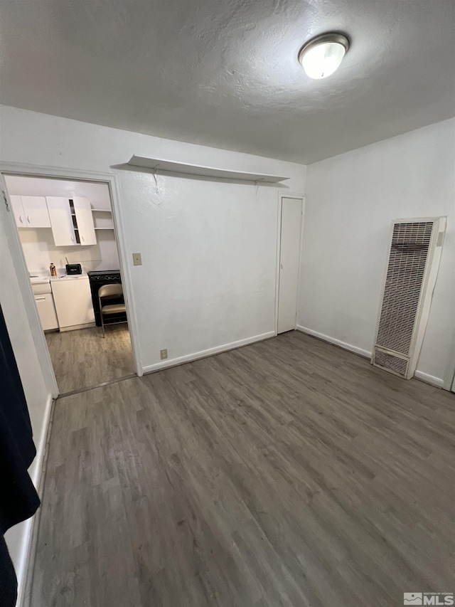 empty room featuring dark hardwood / wood-style floors and a textured ceiling