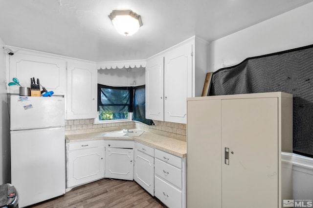 kitchen featuring tasteful backsplash, white cabinetry, white fridge, and light hardwood / wood-style floors